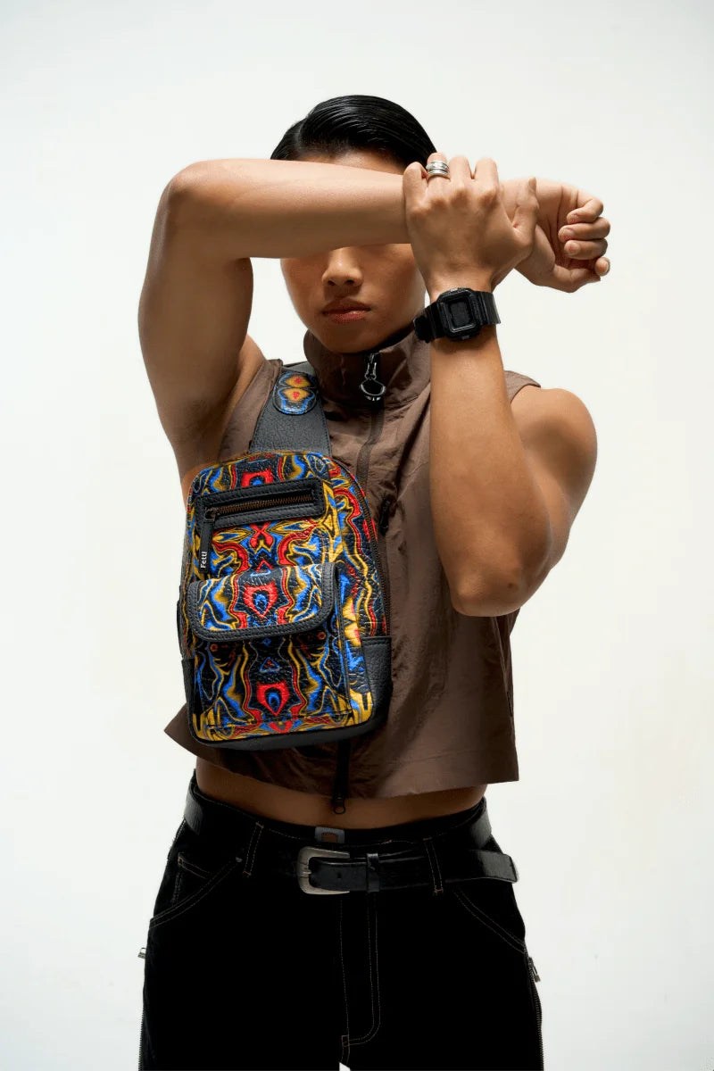 Person wearing a colorful and Compact travel sling bag carrying essentials with a plain background