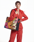 Close-up of a Woman holding FETTI Faces OG tote bag against a gray background