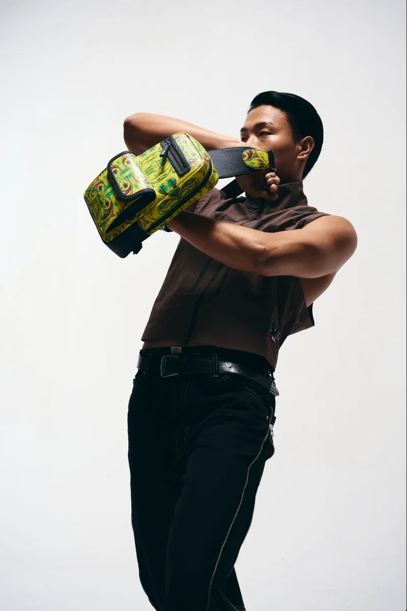 Person holding a kosmic immersion sling bag against a white background