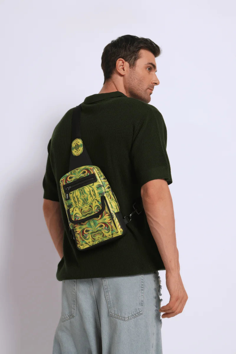 Man wearing a dark t-shirt with a kosmic immersion sling bag helios on his back against a white background