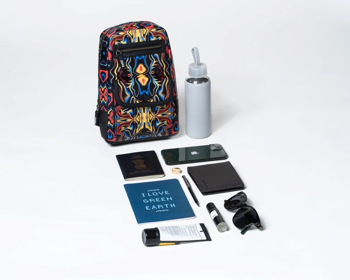 Colorful and stylish crossbody sling bag along with a water bottle, phone, notebook, and other items on a white background, showing the things it can easily hold inside.