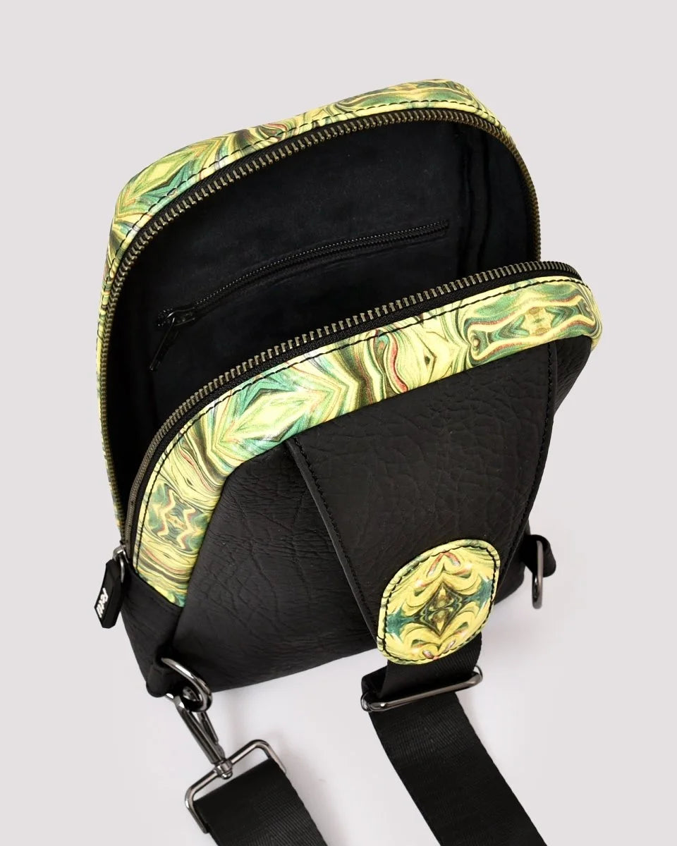 Organized interior compartments of travel sling bag on a light gray background