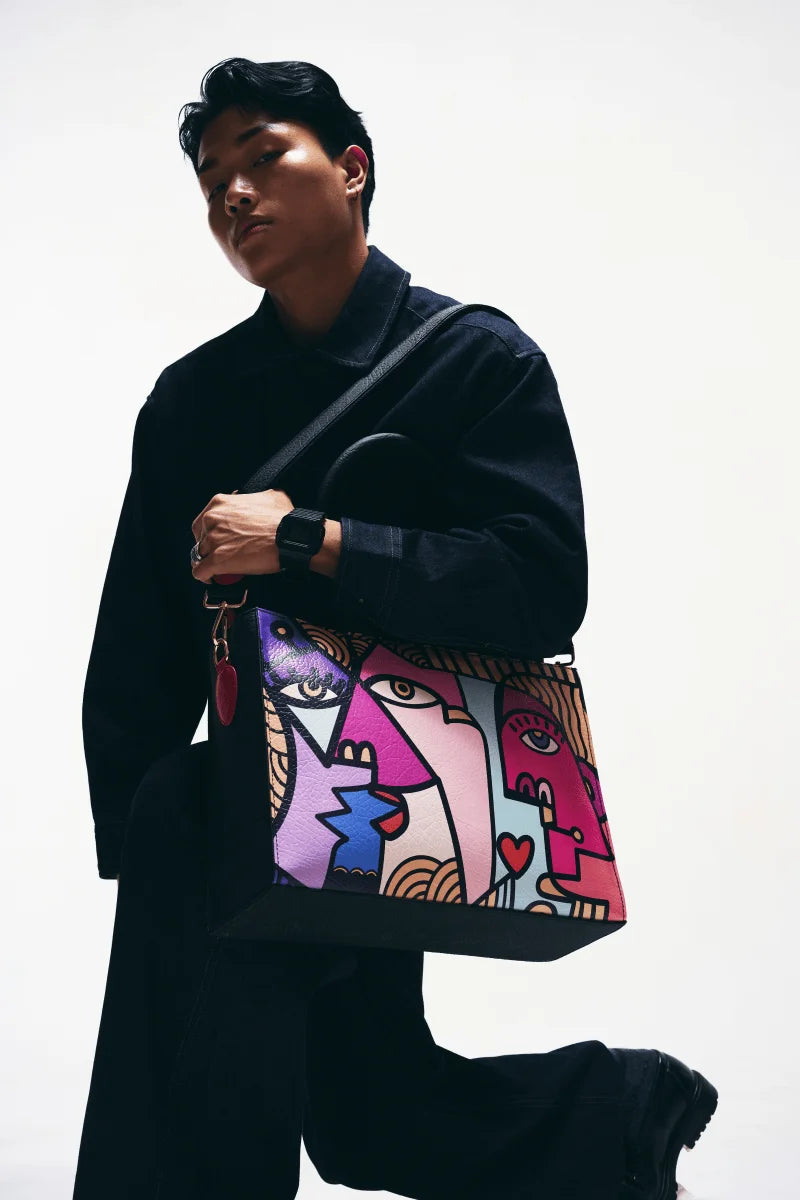 A Man holding a colorful and Stylish everyday tote bag for work and errands against a white background